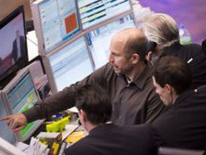Un corredor de bolsa se&ntilde;ala una pantalla con informaci&oacute;n burs&aacute;til en el mercado de valores de Fr&aacute;ncfort (Alemania).