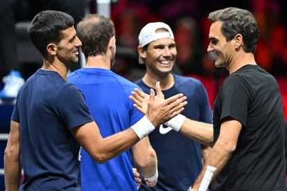 In the foreground, Novak Djokovic (on the left) greets Roger Federer.  In the background, Murray and Nadal.