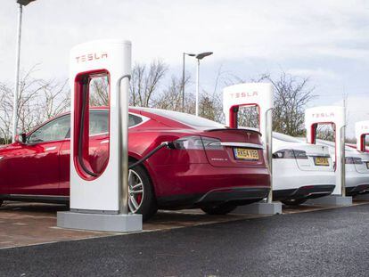 Coches eléctricos de Tesla enchufados a postes de carga.