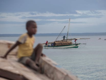 Varias personas transportan madera en una embarcación frente a la costa de Paquitequete, en Mozambique.