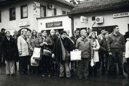 Un grupo de personas esperan la llegada del tranvía en Sarajevo.