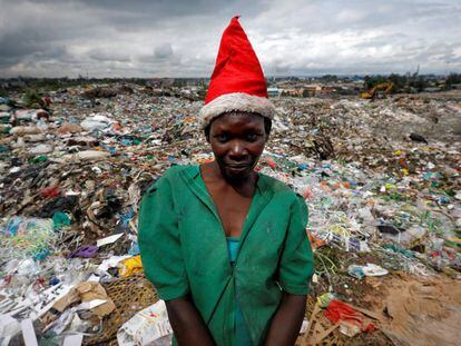 Una joven con gorro de Santa Claus posa delante del vertedero de Dandora, en Nairobi, Kenia.