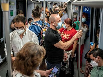 Decenas de pasajeros, en agosto de 2020 en los vagones de uno de los trenes que recorre la linea 10 del metro de Madrid.