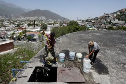 Maria Luisa Robles y su vecino toman agua de un tanque de almacenamiento de agua público, en Monterrey (México), durante una severa sequía que asoló el noreste del país.