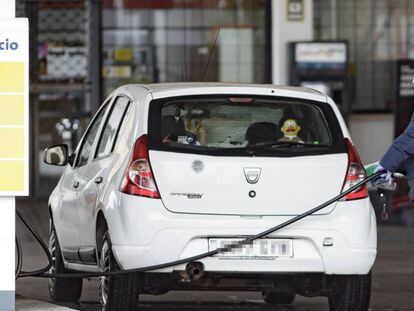 Un hombre reposta carburante en una estación de servicio.