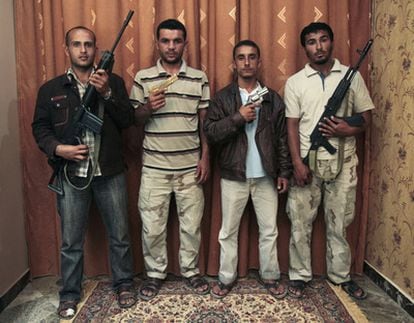 Los primeros rebeldes libios que descubrieron y desarmaron a Gadafi posan con armas del dictador y sus guardianes. De izquierda a derecha, Ahmed Ghazal, Nabil Darwish, Omran Shaban ySalem Bakir.