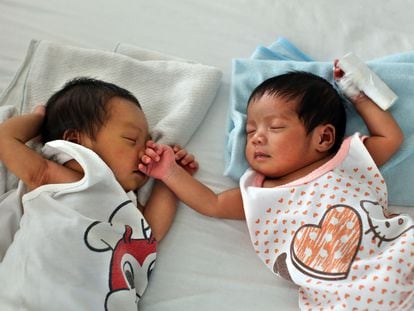 Dos bebés duermen en una cama en la llamada 'fábrica de bebés' de Manila.