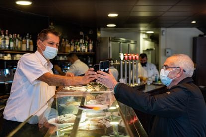Un camarero escanea el código QR del certificado de vacunación de un cliente en un bar de Barcelona, el pasado viernes.