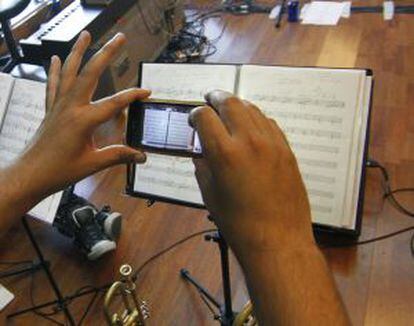 Un músico copia una partitura en su móvil.