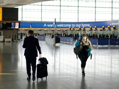 Una viajera transita con máscara por una de las terminales vacías del aeropuerto de Heathrow.