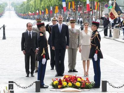Hollande (izq) acompaña a los Reyes en la ofrenda floral, en París.