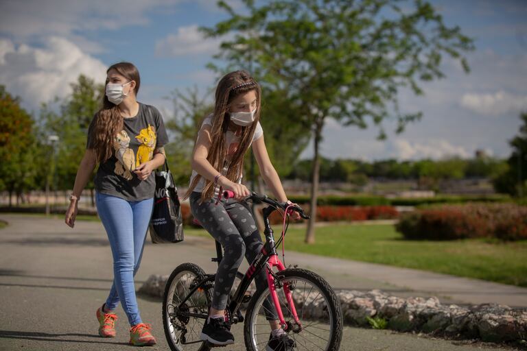 Una mujer y su hija pasean por un parque de Sevilla, este martes.