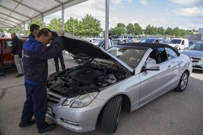 Un mecánico inspecciona el motor de un coche en el Salón VO 2018.
