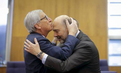 El presidente de la Comisión Europea, Jean-Claude Juncker (izquierda), besa en la frente al comisario europeo de Asuntos Económicos, Pierre Moscovici