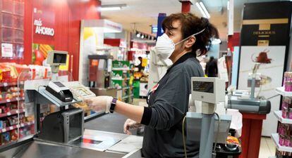 Cajera de un supermercado provista con elementos de protección frentre al coronavirus.
 