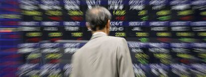 Un empresario observa un panel electr&oacute;nico exhibido en un edificio de Tokio (Jap&oacute;n) que muestra varios valores burs&aacute;tiles de la sesi&oacute;n de la Bolsa de Tokio. 