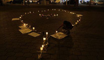 Una chica enciende unas velas en memoria de los normalistas de Ayotzinapa.