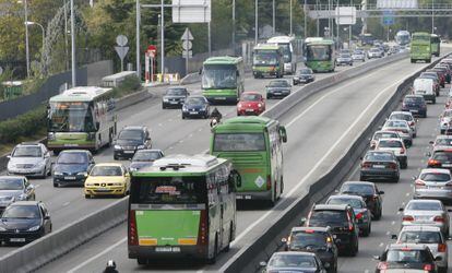 Varios autobuses interurbanos circulan por distintos carriles de la A-6, incluido el Bus-VAO, un d&iacute;a laborable con atascos.