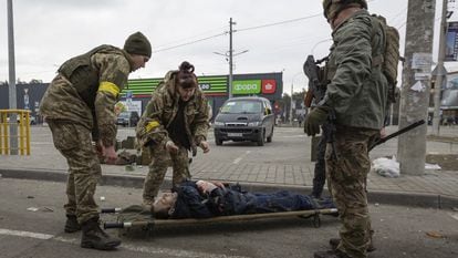 Militares ucranios ayudan a un herido en Irpin, cerca de Kiev.