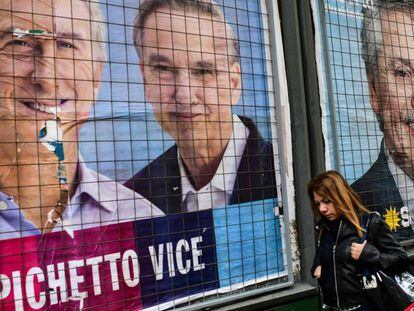 Una mujer pasa por delante de carteles de propaganda de Mauricio Macri y Alberto Fernández en una calle de Buenos Aires.