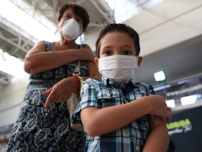 Un niño y su abuela tras recibir una vacuna contra la influenza, el 16 de marzo de 2020 en Santiago (Chile).