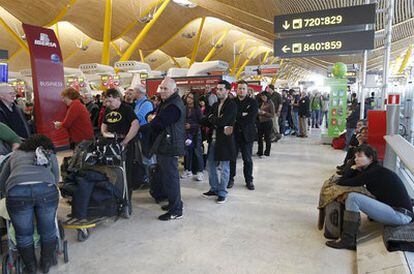 Pasajeros esperan su turno en la zona de facturación de la T4 del aeropuerto de Barajas.