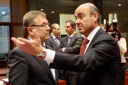 El ministro español de Economía, Luis de Guindos, conversa con el ministro húngaro Gyorgy Matolcsy, al comienzo de la segunda jornada de la reunión del Ecofin