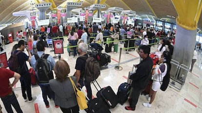 Decenas de personas hacen cola en el Aeropuerto de Barajas de Madrid.