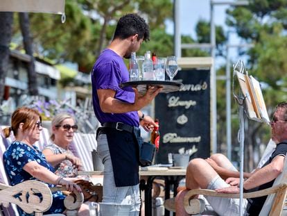 Un camarero atiende a unos clientes de una mesa, en la terraza de un restaurante del Paseo Marítimo de Platja dAro (Costa Brava-Girona) /Toni Ferragut