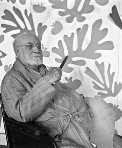 Matisse, en su estudio del hotel Régina de Niza, delante de sus célebres gouaches sobre papel.
