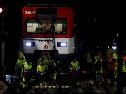 Varios operarios, junto al tren de Cercanías que descarriló el martes 5 en la entrada de la estación de Atocha.