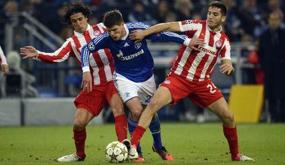 Modesto y Manolas,d el Olympiacos, tratan de frenar el avance de Huntelaar, del Schalke.
