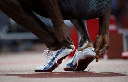 El atleta jamaicano Usain Bolt se quita las zapatillas depués de vencer en la semifinal de los 200 metros.
