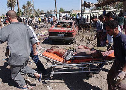 Un equipo de rescate porta en una camilla los restos de un hombre asesinado en uno de los atentados de ayer en Bagdad.