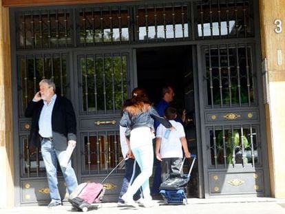 Unos vecinos acceden al portal del edificio donde se encuentra la casa escenario de los crímenes del pederasta.