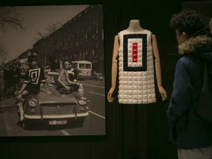 Un visitante observa un diseño de Devota & Lomba de 2016 junto a una foto de varias modelos en la calle Serrano (Madrid) en los sesenta.