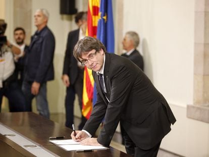 El expresidente de la Generalitat de Cataluña, Carles Puigdemont, firmando la declaración de independencia en el Parlamento de Cataluña, en octubre de 2017.