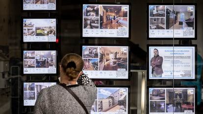 Una mujer mira anuncios de vivienda en una inmobiliaria de Barcelona, en una imagen de archivo.