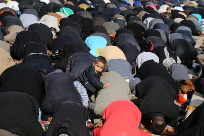 Los seguidores del clérigo chií Muqtada al-Sadr se agolpan en una calle al aire libre para asistir a las oraciones del viernes en el bastión chiíta de Sadr City, en Bagdad, Irak.
