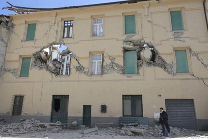 Una mujer habla por teléfono al lado de un edificio destruido debido al terremoto en Amatrice (Italia). 