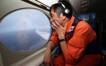 Koji Kubota, un miembro del servicio de guardacostas de Jap&oacute;n, observa el oc&eacute;ano desde un Gulfstream V en busca del MH370. 