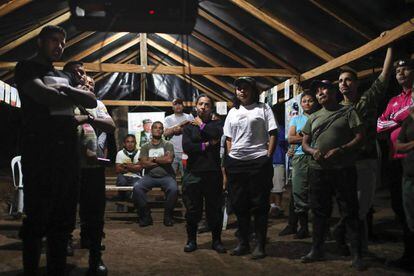 Guerrilleros de las FARC ven la televisión en un campamento.
