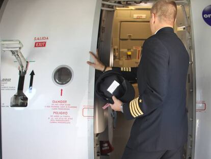 Un piloto de Iberia accede a la cabina de su avión.