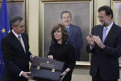 Ramón Jáuregui entrega la cartera ministerial a Soraya Sáenz de Santamaría en presencia de Rajoy.
