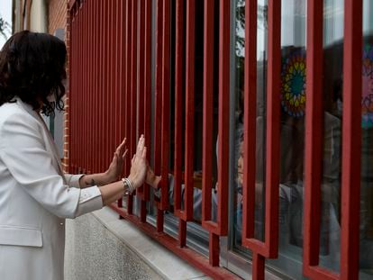 La presidenta de la Comunidad de Madrid, Isabel Díaz Ayuso, le da la mano a una niña del colegio concertado de Alcobendas Padre Manyanet, durante un acto para presentar el programa del PP en materia de educación, el 27 de abril de 2021.