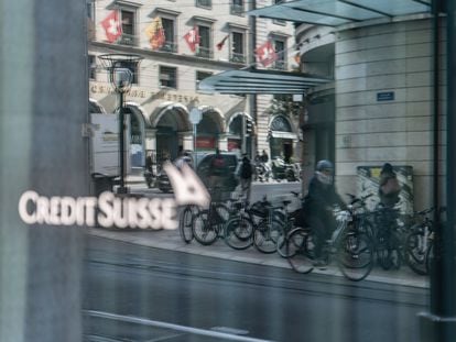 Un ciclista pasa ante el escaparate de una sucursal de Credit Suisse en Ginebra.