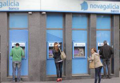 Usuarios de los cajeros en una sucursal de Novagalicia Banco. EFE/Archivo