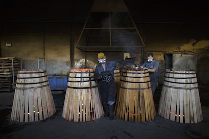 Las cooperativas de Jeréz están especializadas en la producción de barricas de roble para el whisky, aunque también producen algunas para bodegas. En la imagen, dos toneleros tradicionales montan barricas de roble con agua y fuego en la tonelería Antonio Paez Lobato en Jeréz de la Frontera, España.