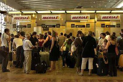 Grupos de pasajeros tratan de recabar información en las oficinas de Iberia.