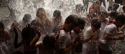 Varios niños con ropa de sanfermines reciben agua durante un encierro infantil en las colonias de verano de 2008 en Getaria, País Vasco.